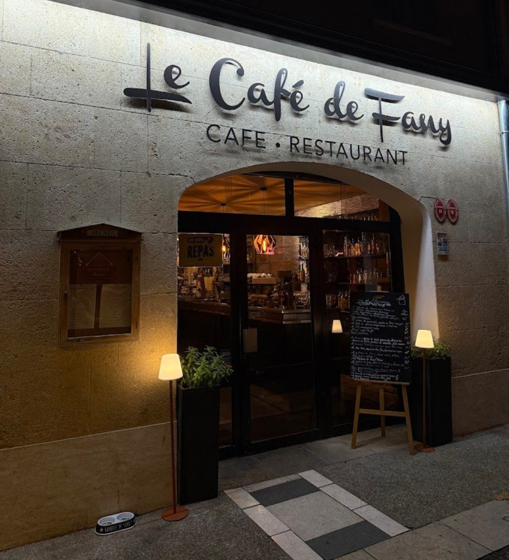 La façade du café le soir, enseigne « Le Café de Fany », porte ouverte sur la salle